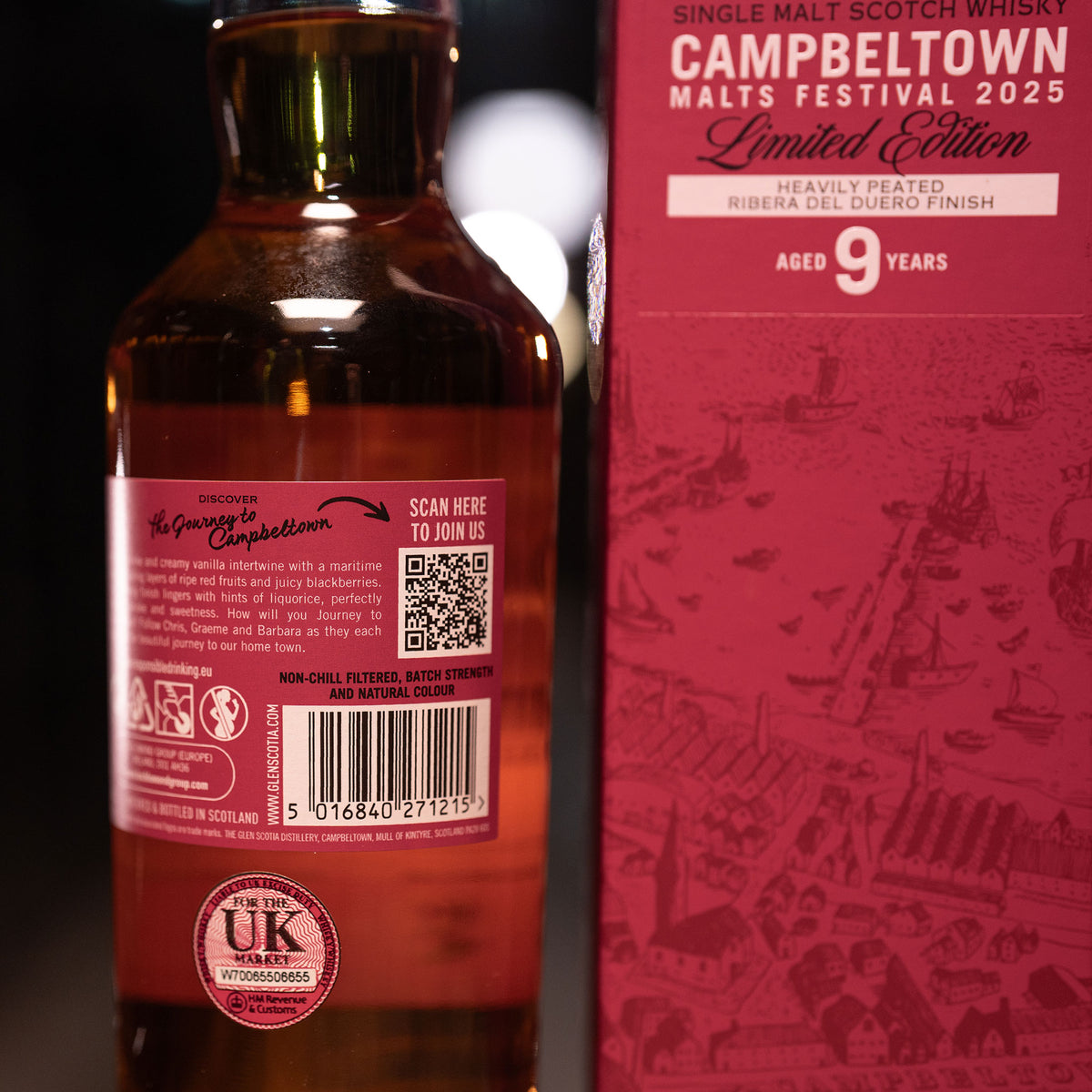 A bottle of Glen Scotia&#39;s heavily peated single malt Scotch whisky, the Campbeltown Malts Festival Edition 2025, stands next to its box. Aged 9 years in Ribera del Duero red wine casks, it features a QR code and UK product label.