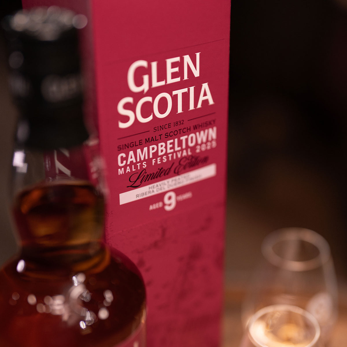 A Glen Scotia Campbeltown Malts Festival Edition 2025 bottle, matured in Ribera del Duero red wine casks, stands next to a red box labeled &quot;Campbeltown Malts Festival 2020, Limited Edition, 9 Years.&quot; A whisky glass is partially visible beside it.